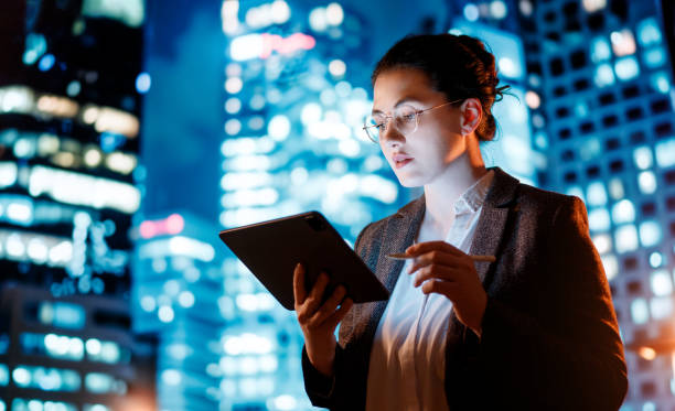 Young businesswoman using tablet pc in the city in the evening.
